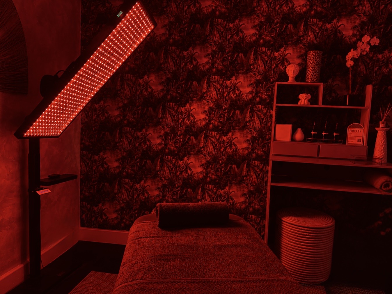 Full-body red light panel beside the treatment bed
