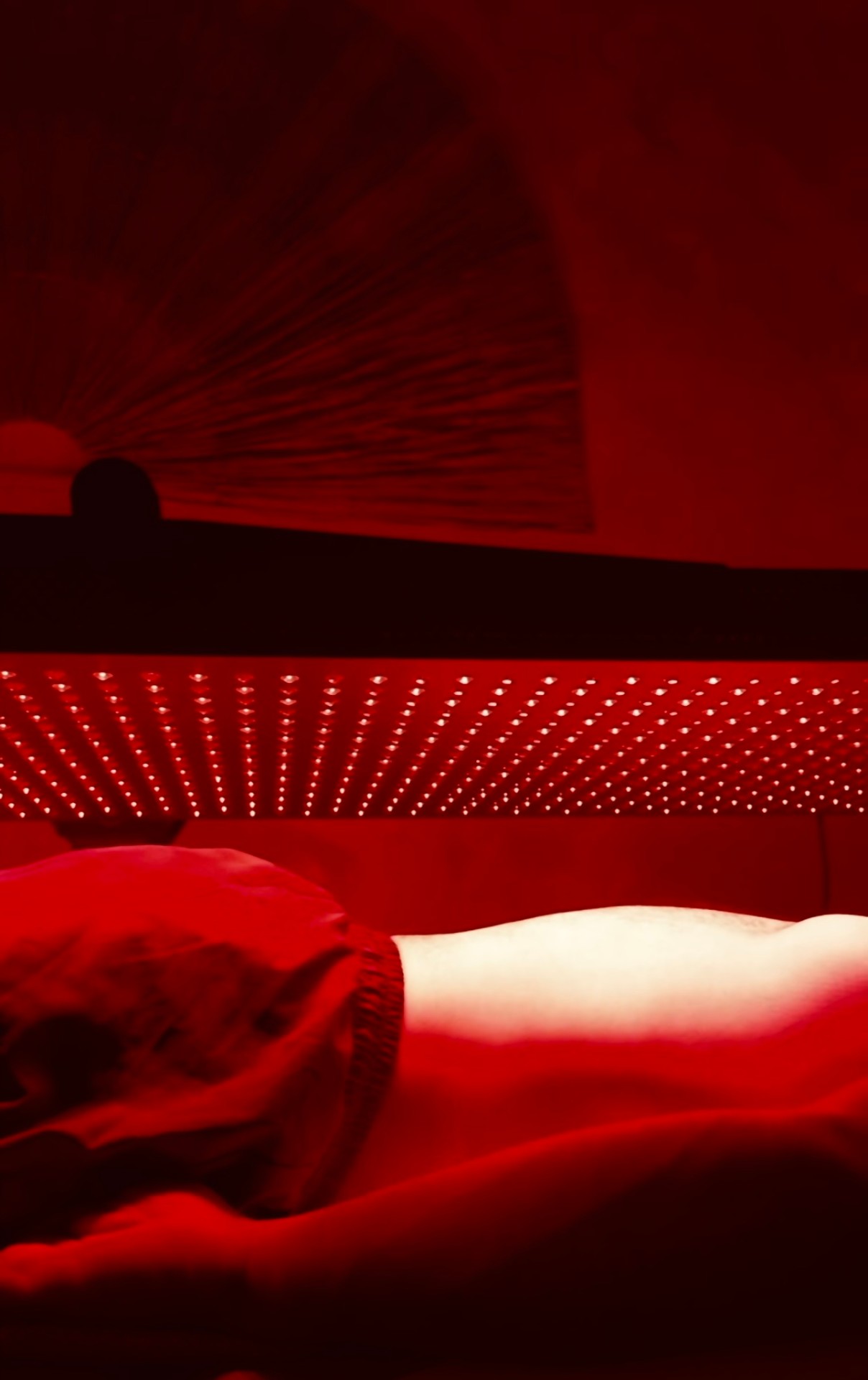 Guest relaxing under the red light therapy panel
