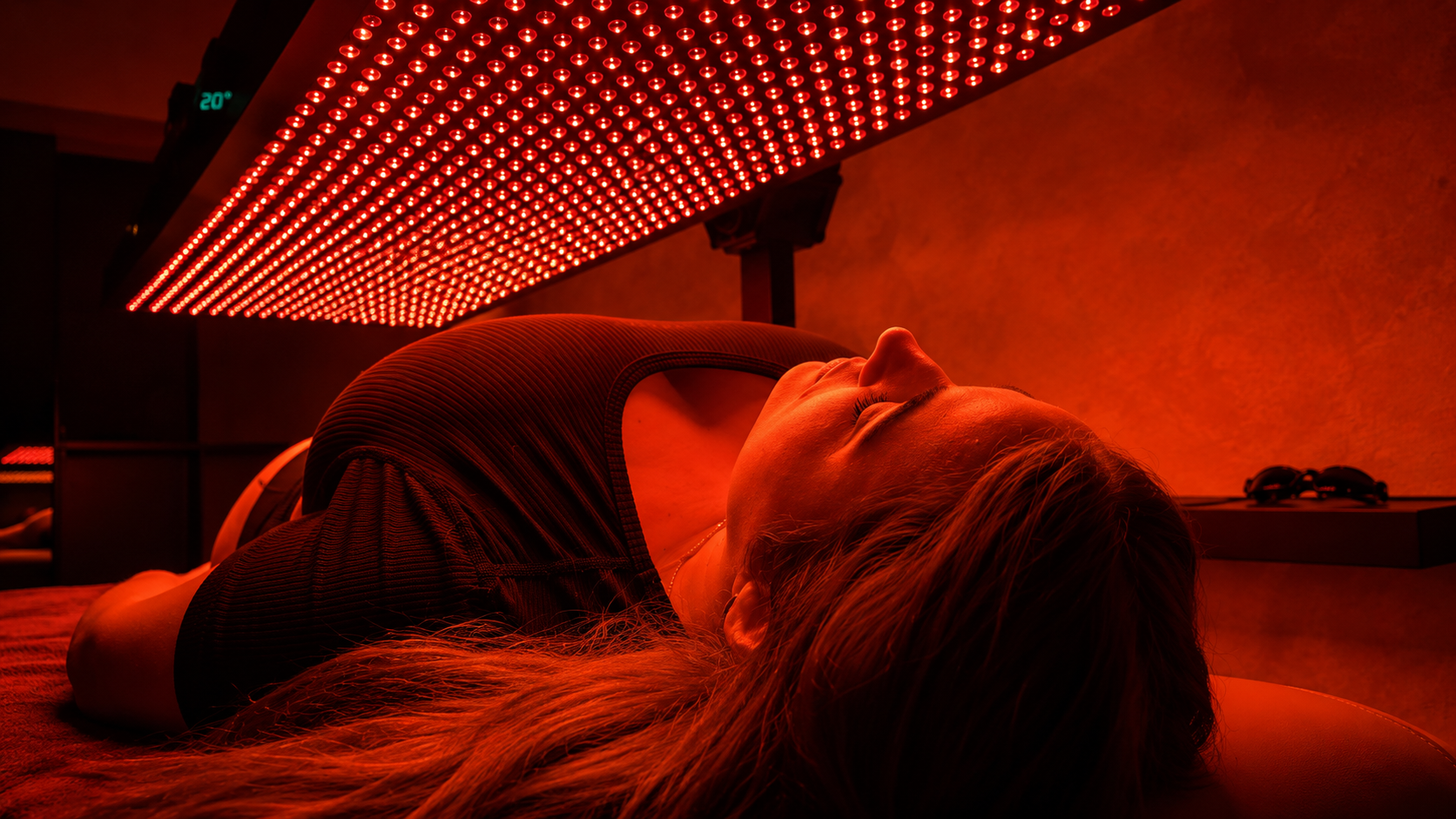 Guest relaxing under the red light therapy panel